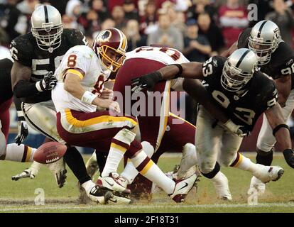 Oakland Raiders defenders Derrick Burgess (56), Stuart Schweigert