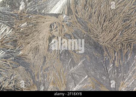 Winter snowy frosty patterns on the glass window. Winter magic. Frosty wonders. Abstract patterns. Stock Photo