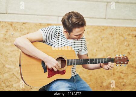 Handsome man playing guitar in studio Stock Photo