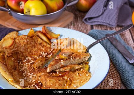 Rice pancake with glazed apples, roasted almonds and cinnamon on a plate Stock Photo