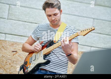 Handsome man playing guitar in studio Stock Photo