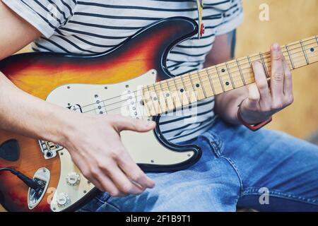 Handsome man playing guitar in studio Stock Photo