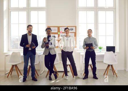 Group portrait of multiracial office workers posing in front of the camera in the office. Stock Photo
