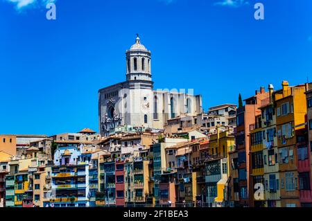 Girona, Spain - July 28, 2019: Colorful houses with balconies at the Jewish quarter of Girona, Catalonia, Spain, with Saint Mary cathedral overlooking Stock Photo