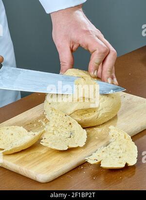 Cook cuts bread for cooking stuffed fish full collection of culinary recipes Stock Photo