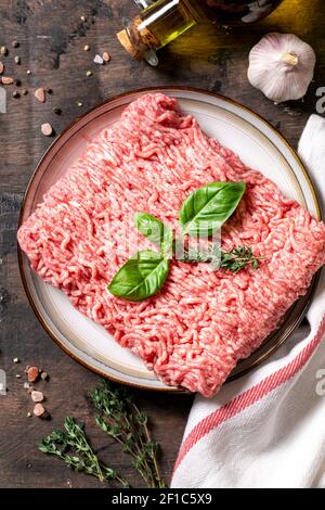 Mince. fresh raw minced meat on a plate and wooden background. Stock Photo