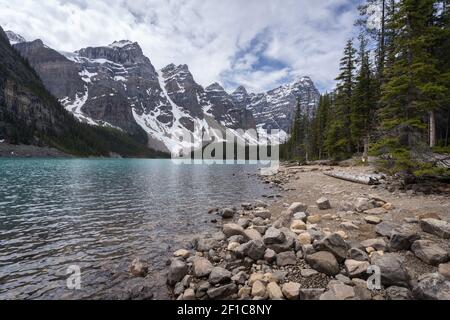Beautiful alpine lake with turquoise waters surrounded by magnificent peaks, wide shot made on a overcast day at Moraine Lake, Banff National Park Stock Photo