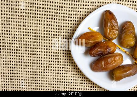 Top view of Algerian royal dates on a white plate, Ramadan concept, space for text Stock Photo