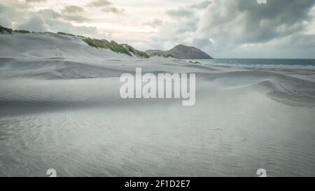 White sand dunes on the beach, shot during sunset on Wharariki Beach, New Zealand Stock Photo