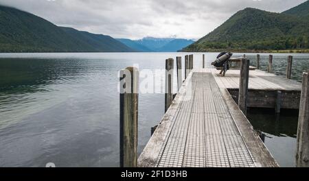 Jetty on the bank of lake surrounded with mountains, shot at Nelson Lakes National Park, New Zealand Stock Photo