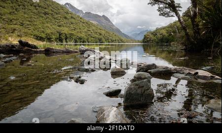 Lake in the middle of forest reflecting its surroundings. Shot on Routeburn Track, New Zealand Stock Photo