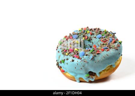 View of sweet donut with blue icing and crushed candies. Close Up of a round confectionery. Donut on a white background. Sweet dish. Ready to eat. Swe Stock Photo