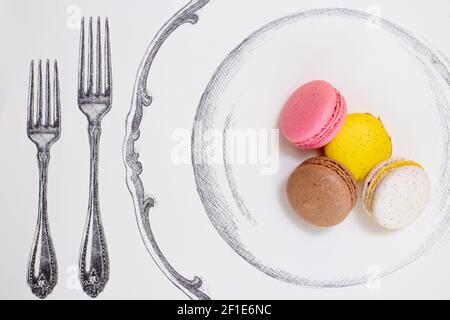Macarons served on a plate next to a tall and small fork Stock Photo