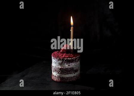 Delicious  red velvet cake with a single candle on a black background, close up, isolated Stock Photo