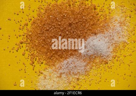 Various kinds of sugar on yellow paper sheet as kitchen theme background Stock Photo