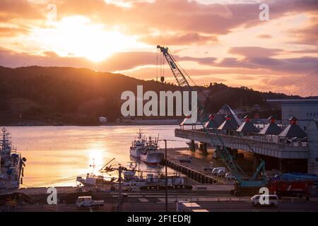 Fishing vessels unload their catch at the port in Kesennuma,  Miyagi Prefecture, Japan on 19 Feb. 2021. March 11, 2021 marks the 10th anniversary of the earthquake and tsunami that devastated the entire region taking more than 18,000 lives and wiping out hundreds of thousands of homes and businesses.  Photographer: Robert Gilhooly Stock Photo