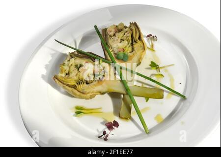 baked stuffed artichokes in plate isolated on white, top view Stock Photo