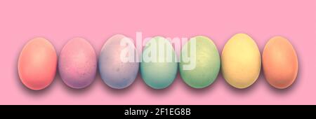 Pastel painted Easter eggs aligned in a row on pink panoramic background, Easter web banner Stock Photo