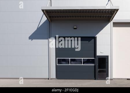 Closed white roller shutter door - automatic metal roller door used in factory, storage, garage. Stock Photo
