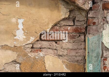 Old damaged plastered facade house wall closeup as grunge background Stock Photo