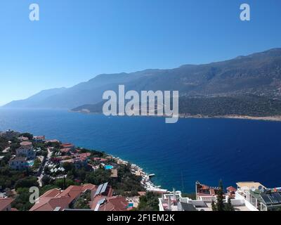 Birds eye view of beautiful turquoise Mediterranean Sea at Kas, Antalya. Summer houses and villas with pools at the coast and green forests. Stock Photo