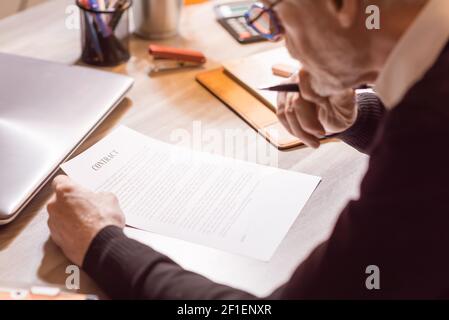 Senior businessman reviewing terms of contract at office Stock Photo