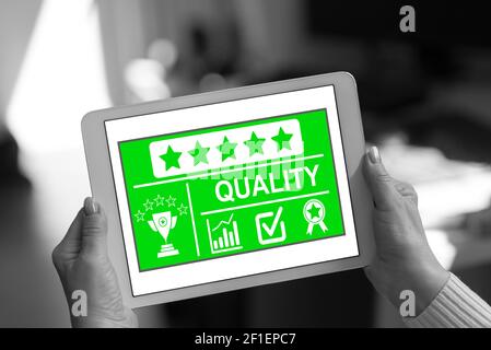 Quality concept shown on a tablet held by a woman Stock Photo