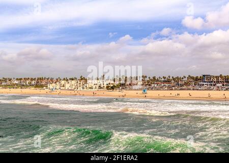 Vibrant Huntington Beach during a sunny day shows the aqua green water and golden shoreline. Stock Photo