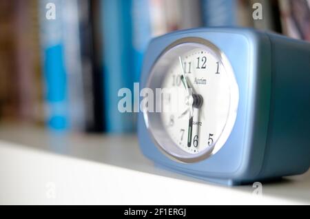 retro style alarm clock on book shelf Stock Photo