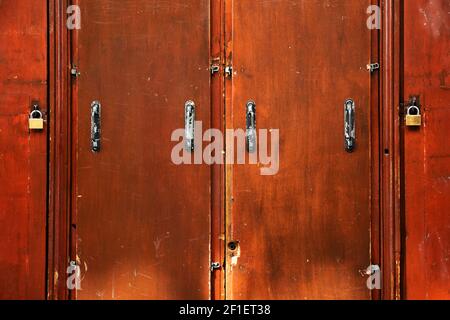 Double security. Old brown doors closed with padlocks. Safety concept. Abstract vintage background. Stock Photo