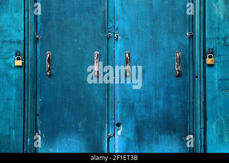 Double security. Old blue doors closed with padlocks. Safety concept. Abstract vintage background. Stock Photo