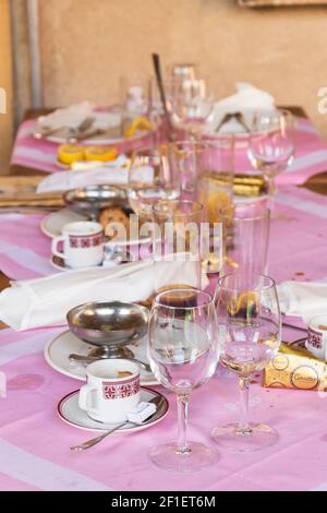 PARIS, FRANCE - SEPTEMBER 1, 2018:  Messy table after brunch party in traditional Parisian cafe. Spilled drinks, dirty dishes empty glasses still life Stock Photo