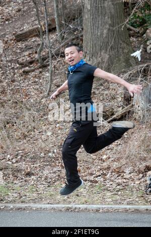 A n athletic nimble young Chinese American man plays Jianzi in a park in Queens, New York City. Stock Photo