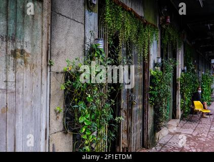 A man sits outside his premises in the Chinatown area of Bangkok, Thailand Stock Photo