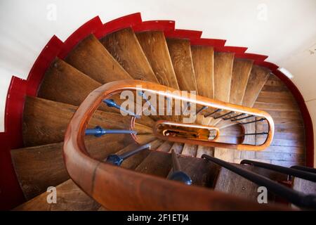 Typical narrow spiral staircase with railing in old Parisian house. Selective focus. Stock Photo