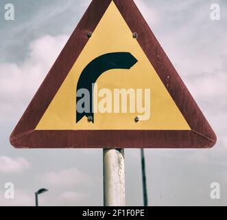 Road signal attention of the curve in the sky Stock Photo