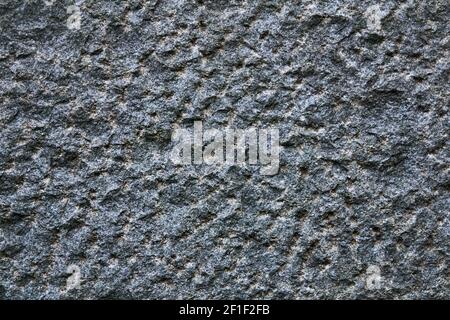 background, texture - the surface of a deliberately rough hewn granite block Stock Photo
