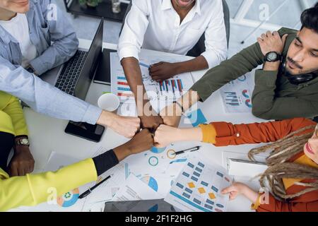 Five multi ethnic students bumping with fists at office Stock Photo