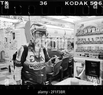 Men in cycling apparel smoking at Pachinko arcade hall in Tokyo , Japan . Stock Photo