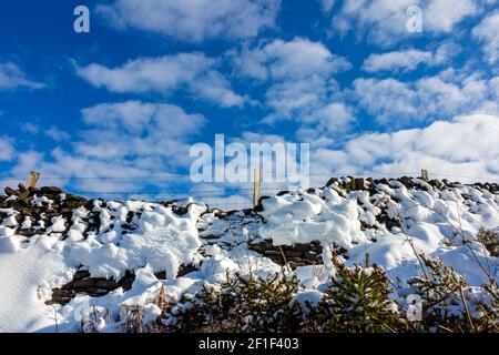 Snow covered landscape with stone wall at Riber above Starkholmes near Matlock Bath in the Derbyshire Peak District England UK Stock Photo