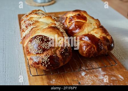 Two Challah Loaves on a Rack Set on a Cutting Board Stock Photo