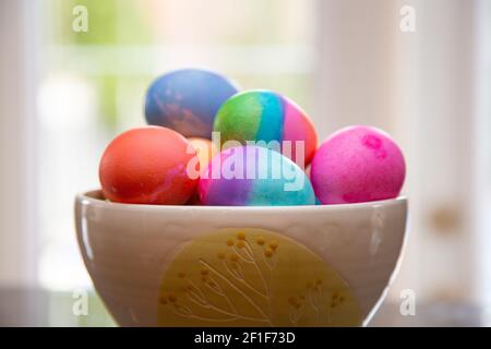 Bowl of brightly colored Easter eggs on diplay Stock Photo