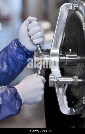 Close up of unrecognizable male worker operating equipment at chemical plant, copy space Stock Photo