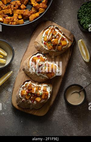 Italian Appetizer Bruschetta with roasted Pumpkin, Red Bell Pepper, Spinach, Garlic and Feta Cheese. Stock Photo