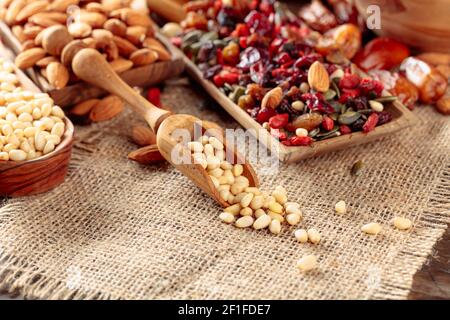 Dried fruits, various nuts, and seeds on an old wooden table. Selective focus. Stock Photo