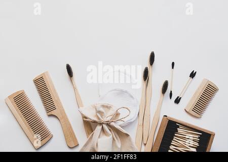 Eco-friendly bamboo toothbrushes, ear sticks, reusable cotton sponges and wooden combs are bathroom products. Zero waste concept. Composition on white Stock Photo