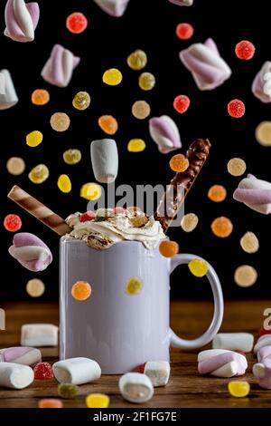Raining candies and marshmallows with coffee whipped cream Stock Photo