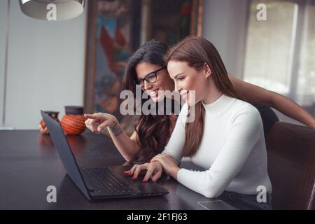 Teacher helping with solution to university student on laptop indoors Stock Photo