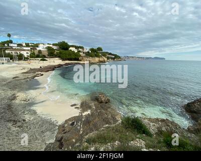 Sea waves lash line impact rock on the beach, located in Alicante, Spain,