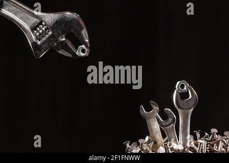 Adjustable Wrench Feeding Baby Wrenches In A Nest Of Nails Stock Photo